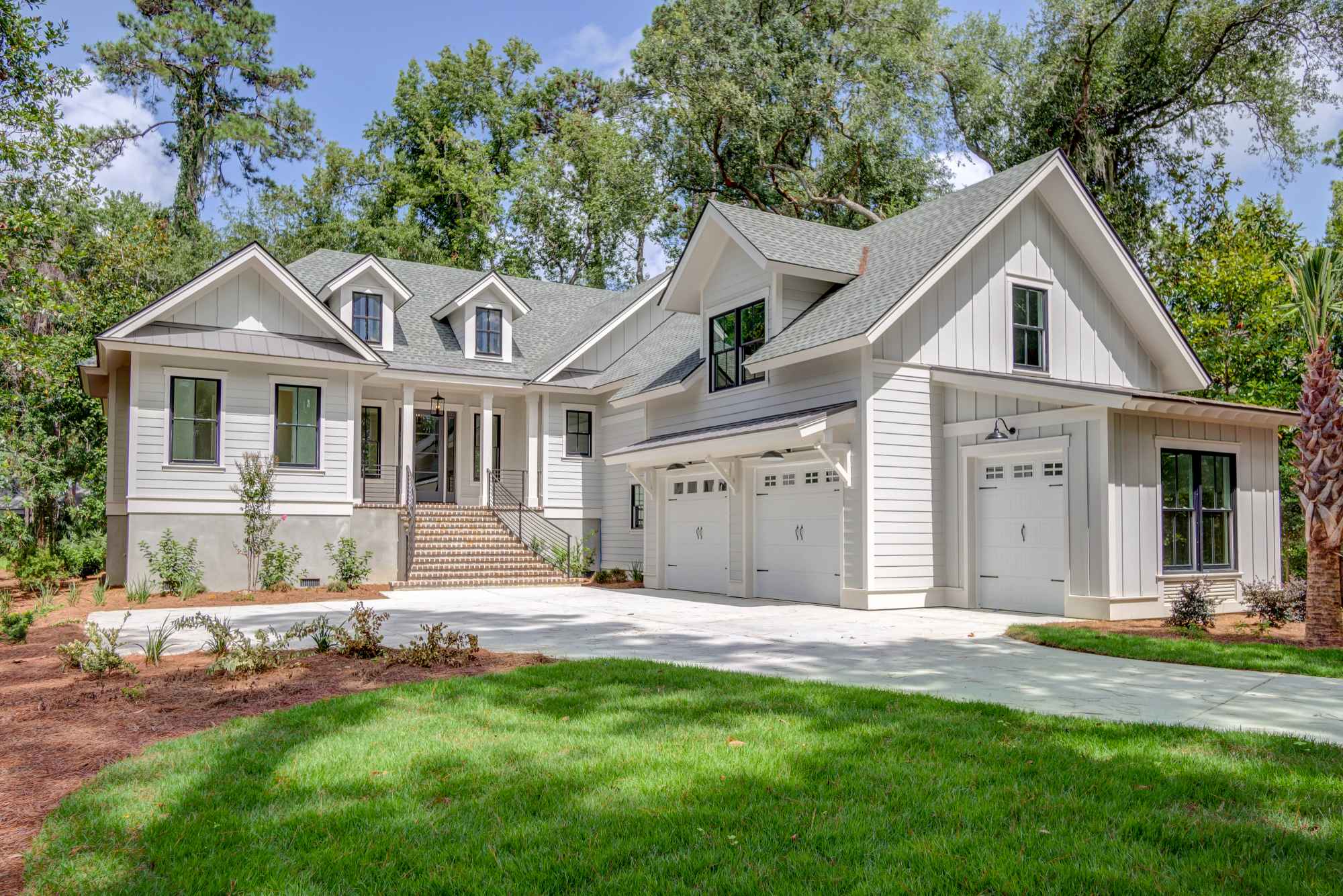 A modern, two-story house with gray siding, white trim, and a spacious garage.