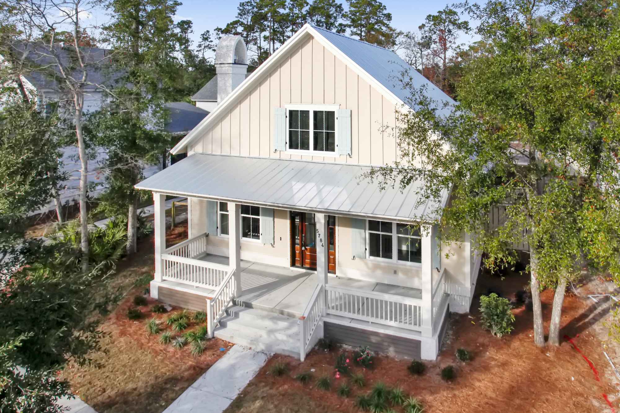 A charming white cottage with a gable roof and front porch.