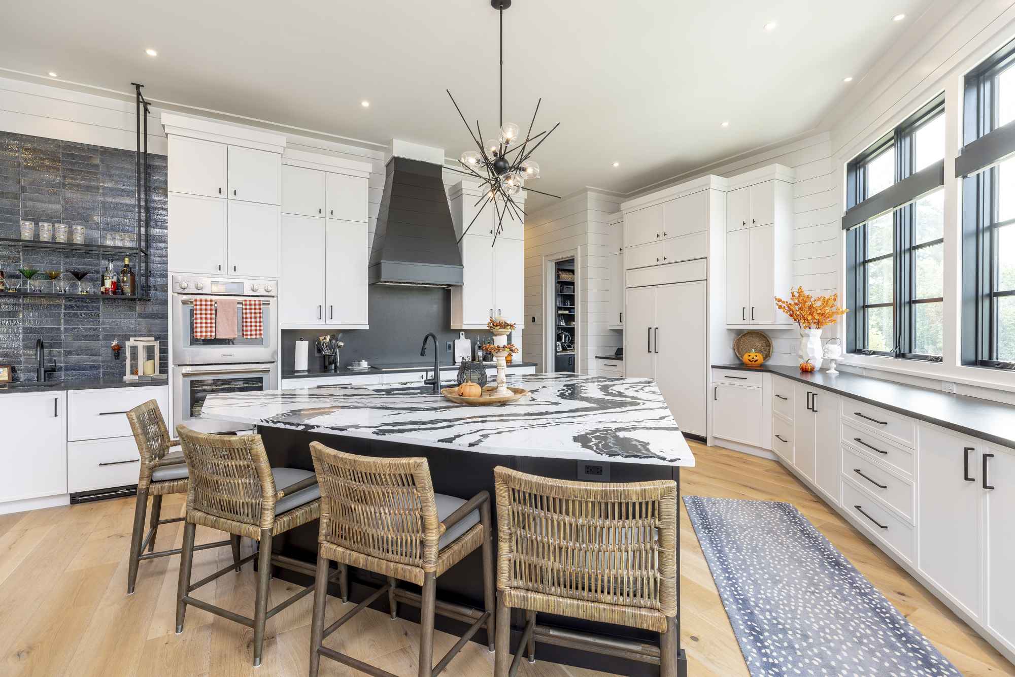 A beautifully patterend marble-topped island is featured in this custom kitchen.