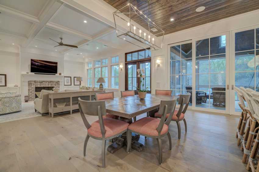 The open floor plan, coffered ceilings and floor-to-ceiling windows are showcased in this photograph.